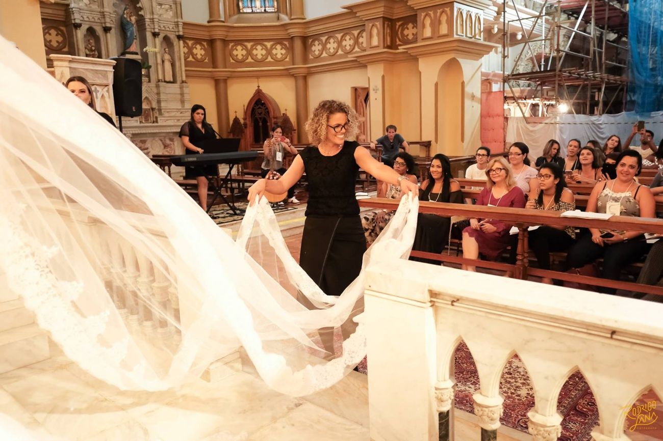 Naligia ajeitando o véu da noiva no altar de uma igreja